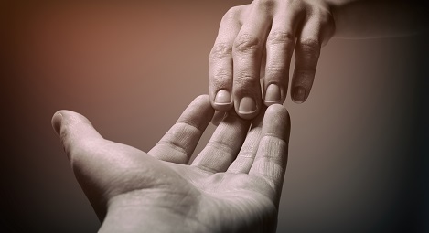 Two hands touching at the fingertips